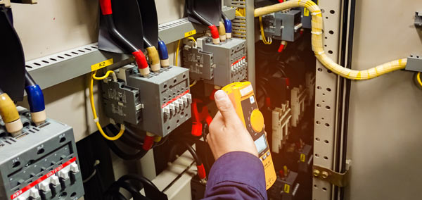 An electrician testing a fuseboard