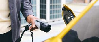 A man plugging in an electric car